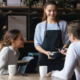 Waitress taking payment with card reader